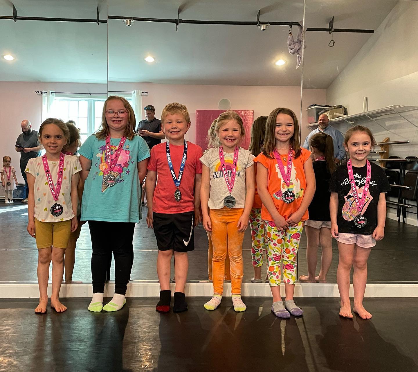 Young classmates smiling with their medals after a season of dance