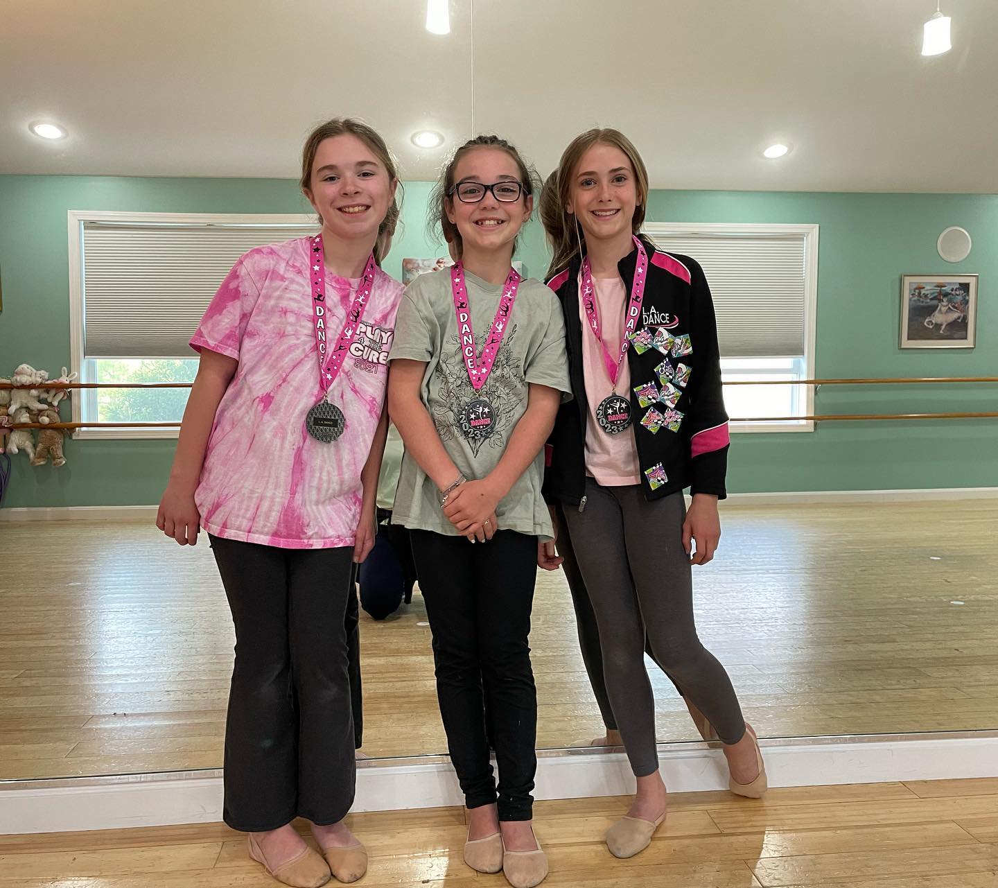 Three L.A. Dance friends celebrating their season with medals