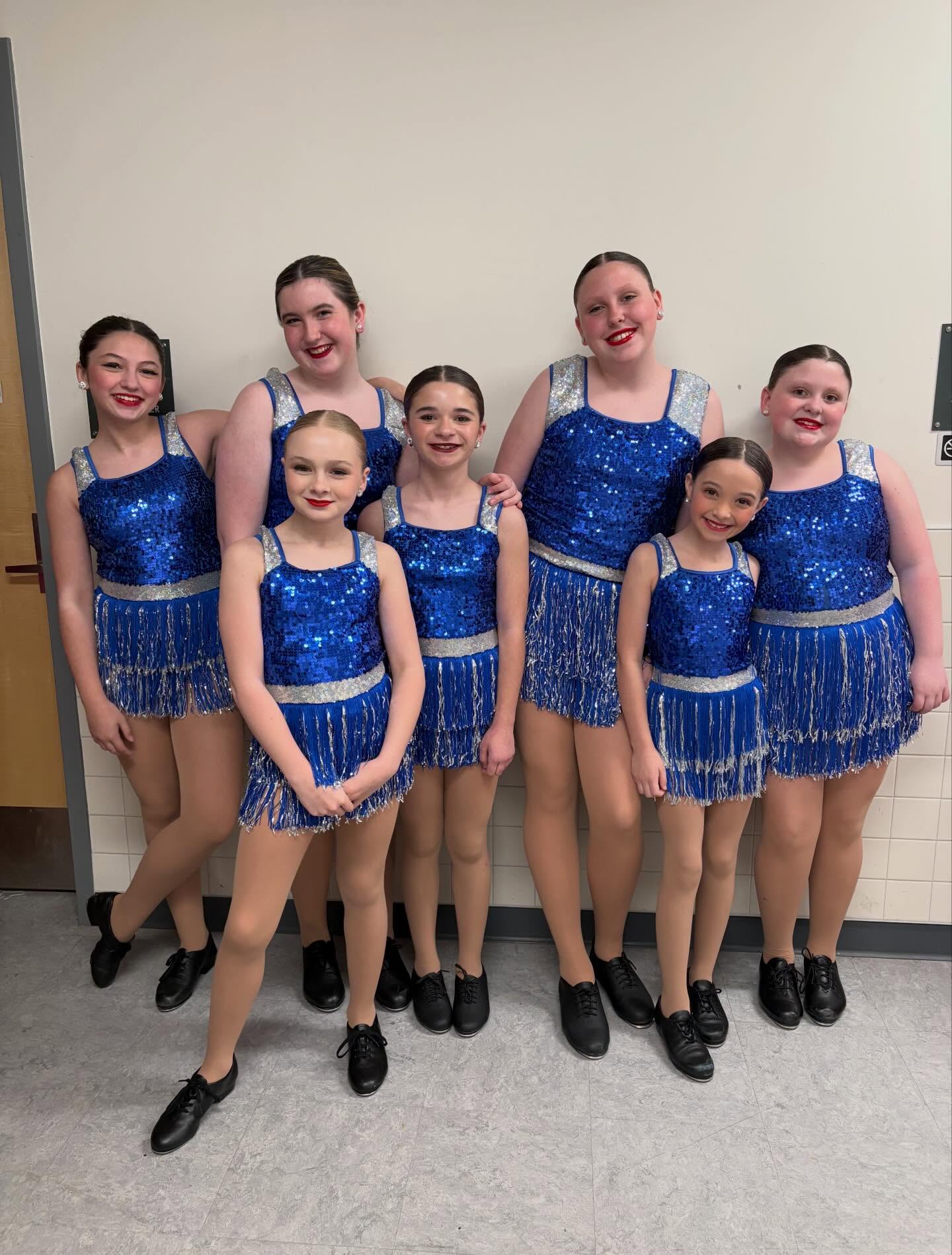 Young dance friends smiling together in blue costumes